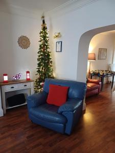 un árbol de Navidad en una sala de estar con un sofá azul en Large countryside home, en Tow Law