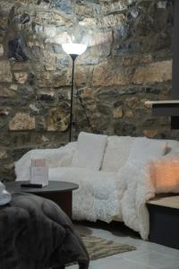 a bedroom with a bed and a stone wall at kaimak luxury chalet in Palaios Agios Athanasios