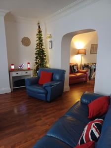 - un salon avec un arbre de Noël et un canapé bleu dans l'établissement Large countryside home, à Tow Law