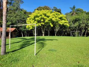 a soccer goal in a field with a tree at Pousada Moinho de Pedra in Extrema