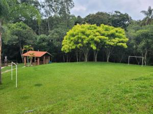 a large field with a house and a soccer ball at Pousada Moinho de Pedra in Extrema