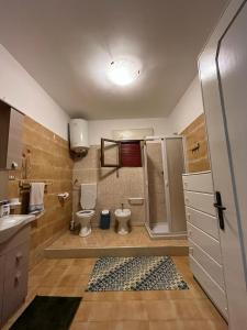 y baño con 2 aseos, ducha y lavamanos. en Casa Vacanze Perla di Mare, en Punta Prosciutto