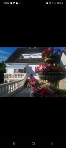 2 fotos de un edificio con flores y balcón en A la maison du bonheur, en Neuilly-sous-Clermont