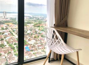 een witte stoel voor een raam bij Sea View One Bedroom Apartment In Bluhen Tower in Batam Center