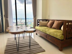 een woonkamer met een bed, een tafel en een raam bij Sea View One Bedroom Apartment In Bluhen Tower in Batam Center