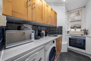 a kitchen with a washer and dryer on a counter at Chic Urban Retreat 1 Bedroom Gem in Covent Garden 3AB in London