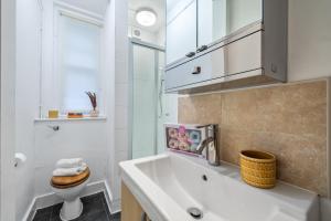 Baño blanco con lavabo y aseo en Chic Urban Retreat 1 Bedroom Gem in Covent Garden 3AB en Londres