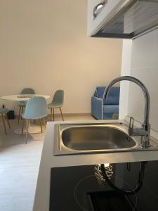 une cuisine avec un évier et une table avec des chaises dans l'établissement VIA ROMA, à Trapani