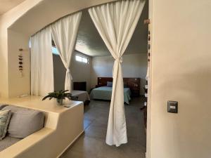ein Schlafzimmer mit einem Bett und einem Fenster mit Vorhängen in der Unterkunft Casa blanca playa saladita in Temalhuacán