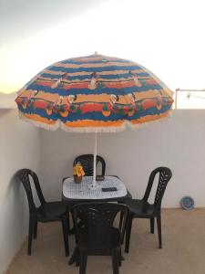 a table with two chairs and a table with an umbrella at Panorama guest house in Sidi Ifni