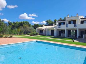 a villa with a swimming pool in front of a house at Comfort relax w pool near beach in Alvor