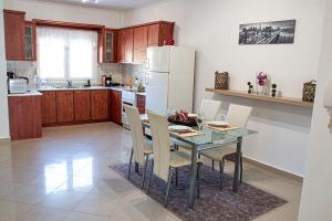 a kitchen with a table and chairs and a refrigerator at Chloe Maxi Apt 110sqm in Kastoria