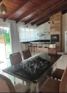 a kitchen with a large table with chairs around it at Rancho lago azul in Guapé