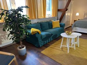 a living room with a blue couch and a table at Hansecottage in Stockelsdorf