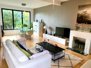 a living room with a white couch and a fireplace at Maison au calme à 20 min du centre de Paris in Nanterre
