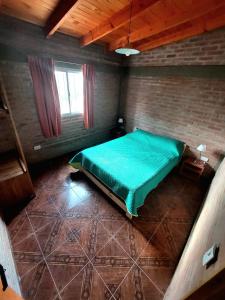 a bedroom with a green bed in a room at Ganesha Casa Vacacional in Las Rabonas