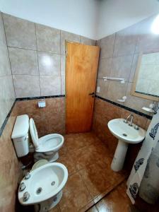 a bathroom with a toilet and a sink at Ganesha Casa Vacacional in Las Rabonas