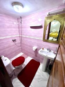 une salle de bains rose avec toilettes et lavabo. dans l'établissement RIAD TENDANCE IN MARRAKECH, à Marrakech