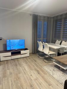 a living room with a table and a tv and chairs at Apartament Górczyn 18 HGS Home in Gorzów Wielkopolski