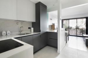 eine Küche mit weißen und schwarzen Schränken und einem Fenster in der Unterkunft Loft 52m²+parking à 15 min de Paris centre in Les Lilas