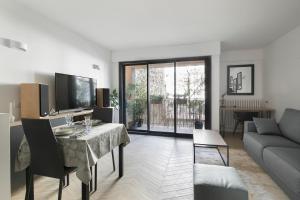 sala de estar con mesa y sofá en Loft 52m²+parking à 15 min de Paris centre, en Les Lilas