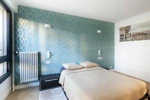 ein Schlafzimmer mit einem Bett und einer grünen Wand in der Unterkunft Loft 52m²+parking à 15 min de Paris centre in Les Lilas