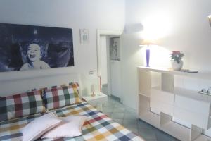 ein Schlafzimmer mit einem Bett mit einem Bild an der Wand in der Unterkunft California in Bari