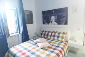ein Schlafzimmer mit einem Bett mit einer karierten Decke in der Unterkunft California in Bari