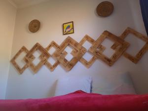 a wall with wooden crosses on a wall at Boilers Surf House in Tamri
