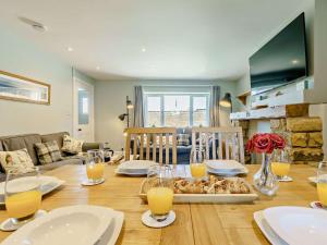 a table with plates and glasses of orange juice on it at 3 Bed in Beadnell CN119 in Beadnell