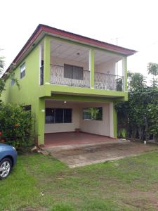 ein grünes Haus mit einem davor geparkt in der Unterkunft La Casa de Eyi 