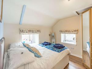 a bedroom with a large bed and two windows at 2 Bed in Seahouses CN116 in Seahouses