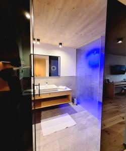 uma casa de banho com uma banheira, um lavatório e um espelho. em Hotel Tirolerhof em Terento