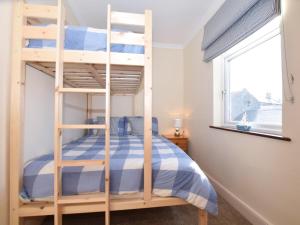 Etagenbett in einem Zimmer mit Fenster in der Unterkunft 2 Bed in Seahouses CN146 in Seahouses