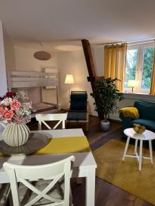 ein Wohnzimmer mit einem Sofa, einem Tisch und Stühlen in der Unterkunft Hansecottage in Stockelsdorf