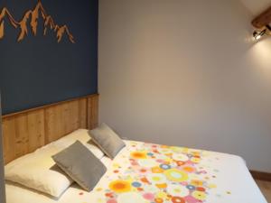 een slaapkamer met een bed met bloemen erop bij la grande ourse in Planay