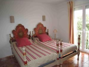 um quarto com uma cama grande e almofadas cor-de-rosa em JARDIN DE CAMILLE LLAURO em Llauro