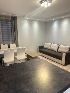a living room with a couch and a table and chairs at Apartament Górczyn 18 HGS Home in Gorzów Wielkopolski