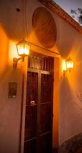 a building with a door and lights on the wall at El Cortijo Tinogasta in Tinogasta