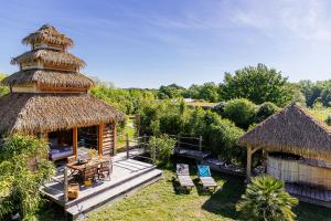 ein Resort mit einer Hütte mit einer Terrasse und Stühlen in der Unterkunft Domaine EcÔtelia in Le Nizan