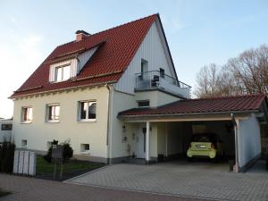 una casa blanca con un coche en el garaje en Hollestübchen en Hessisch Lichtenau