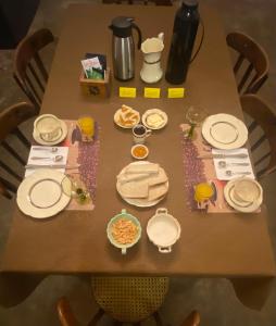 uma mesa de madeira com pratos e comida em El Cortijo Tinogasta em Tinogasta