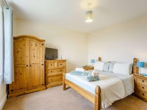 a bedroom with a bed and a wooden dresser at 2 Bed in Boulmer 60464 in Boulmer
