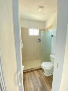 a bathroom with a toilet and a glass shower at Casa Balam Gladiolas in Cancún