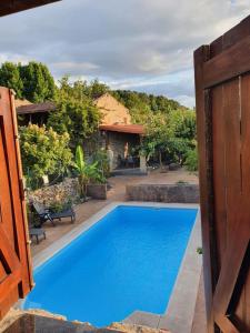 a blue swimming pool in front of a house at casa cristimil -san amaro in Salamonde