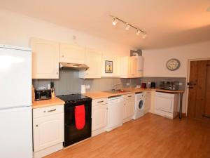 een keuken met witte kasten en een rode handdoek bij 3 Bed in Merstone IC056 