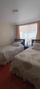 two beds in a room with a window at Casa en la serena in La Serena +19 photos