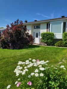 a house with flowers in the yard at Private trendy studio with fireplace in Ottawa