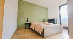 1 dormitorio con cama y pared verde en Willa z Jacuzzi 15 osób Góry Weekend Gorąca Balia Hydromasaż Urodziny Panieński, 