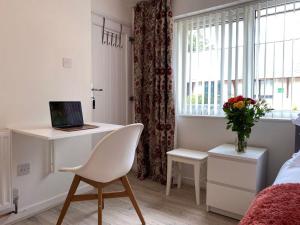 a white bedroom with a desk and a chair and a window at Snowdonia Mountain Lodge in Bethesda